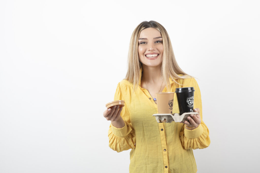 Conviértete en Embajador Goldmez 5 image young woman holding cups coffee while smiling